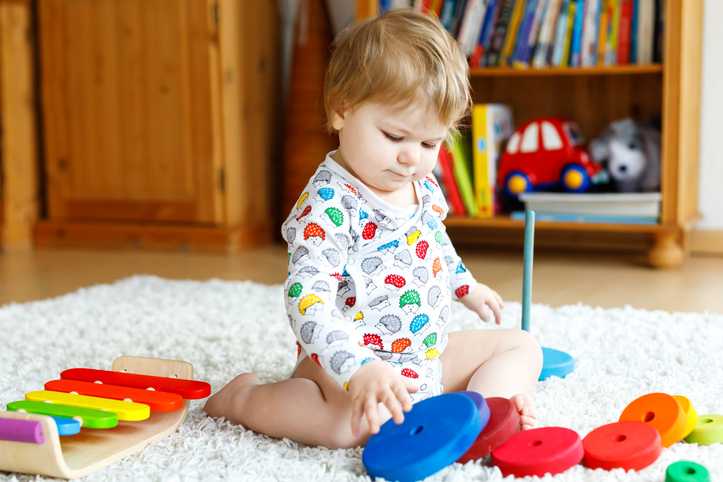  Toddler_ with_ colourful_ stack_ pyramid_ and_ music_ toys